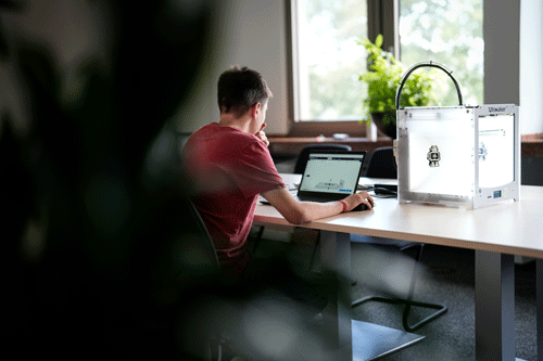 Ein Auszubildender sitzt an einem Laptop