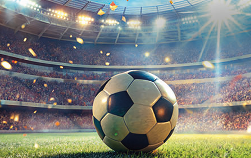 Fußball liegt auf einem Fußballfeld bei Flutlicht