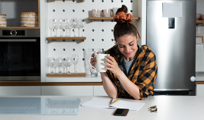 Zufriedene Frau studiert Informationen in Küche