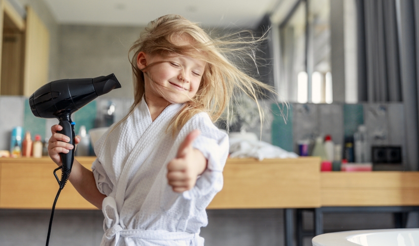 Kleines Mädchen föhnt sich die Haare
