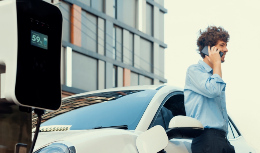 Mann lädt Elektroauto an Ladesäule